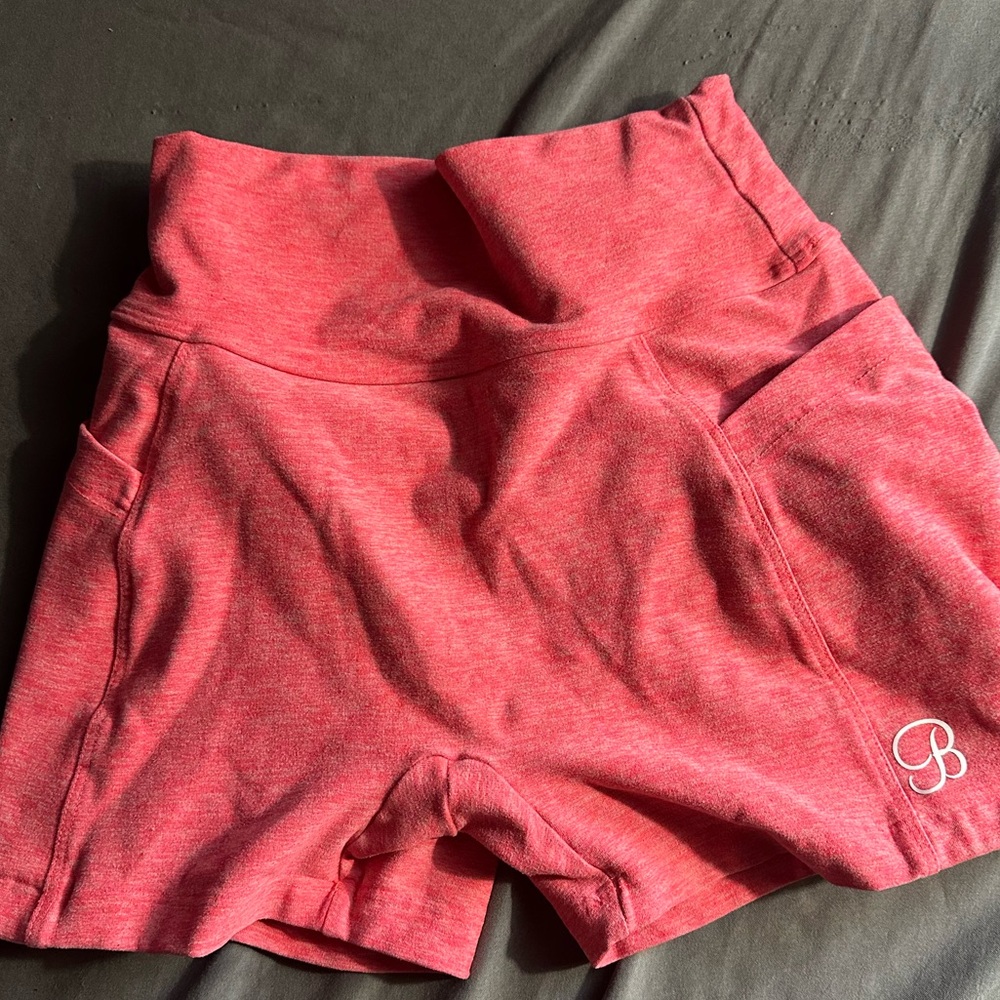 Small women’s 3” bombshell sportswear scrunch butt coral shorts with pockets